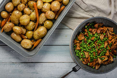 Fried potatoes and chanterelles in a pan. Edible mushrooms and baked vegetables. Healthy and tasty vegetarian organic food. Top viewの写真素材