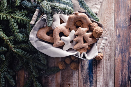 Gingerbread Christmas cookies and fir branches on a rustic table. Homemade traditional New Year or...