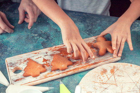 Girl and mom decorate gingerbread cookies. Homemade traditional Christmas pastries. Delicious...