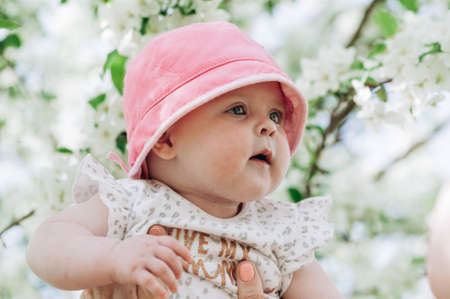 Portrait of a cute baby girl with blue eyes in a pink hat. Close-up. Soft focus. Happy childhood...