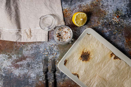 Empty rectangular plate. Rusty background. Forks, spices. Place for display. Top view. Copy space.の写真素材