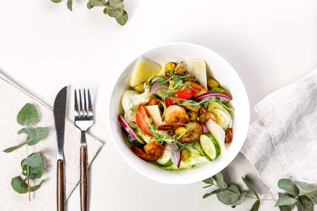 Top view summer salad with fresh vegetables, fried shrimps, cheese and herbs. Seasonal vegetables,...