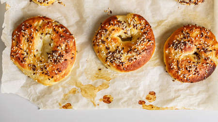 Food banner. Fresh, hot and crispy bagels with sesame and flax seeds. Crusty sesame tasty buns. Homemade baking. The best homemade New York-Style Bagel Recipe. Tasty bagels on baking paper. Copy spaceの写真素材