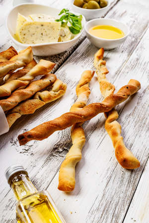 Crispy grissini breadsticks. Traditional Italian wheat bread with garlic, cheese and sesame seeds....