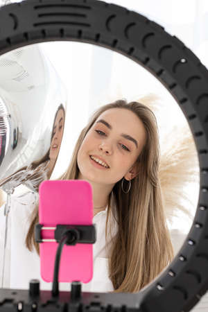 Portrait of a pretty smiling blonde girl on a light background. A beautiful Caucasian girl in a...