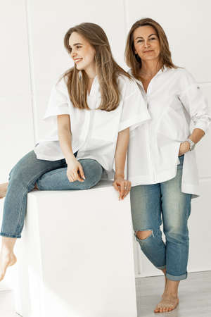 Portrait of a beautiful smiling woman and her adult daughter. Happy family and mother's day concept....
