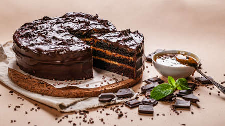 food banner. Chocolate cake with salted caramel on a beige background. Homemade delicious pastries. sweet dessert.の写真素材