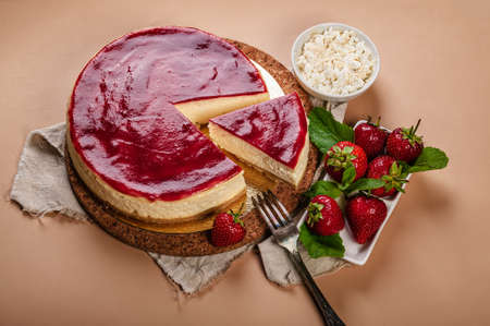 Classic cheesecake with Strawberry jam on a beige background. Homemade delicious pastries. Sweet tasty dessert. close-up. copy spaceの写真素材
