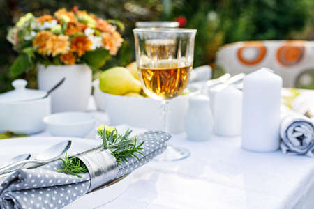 Summer holiday table set up. Elegant table setting with white dishes on a white linen tablecloth....