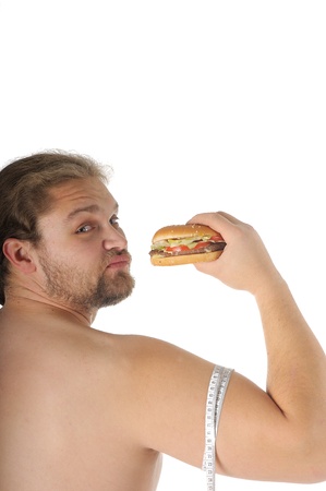 man with hamburger and tape measure around biceps over white background.の写真素材