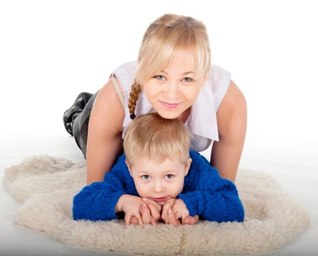 Portrait smiling mother and the child lying at home on the fur.の写真素材