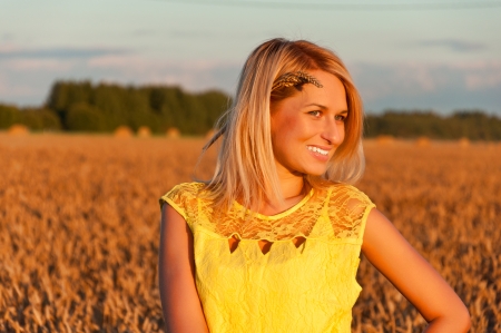 Happy womanin yellow dress  in golden wheat.の写真素材