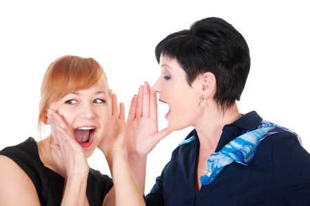 One woman said softly in his ear the other, isolated on white backgroundの写真素材