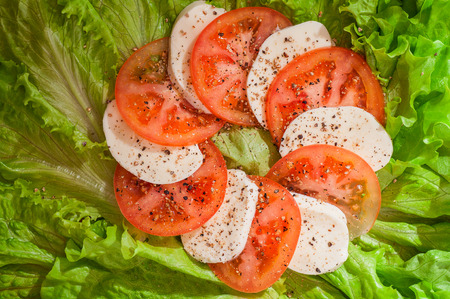 a salad with mozzarella and red tomatoesの写真素材