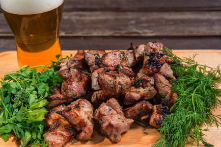 grill meat, green and beer on a woowen plateの写真素材
