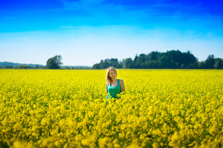 blond woman in a rape field. blue sjy, yellow field