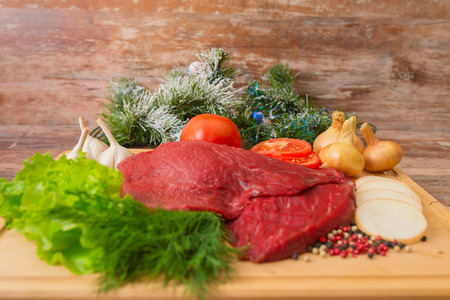 raw beef meat with vegetables on wooden plateの写真素材