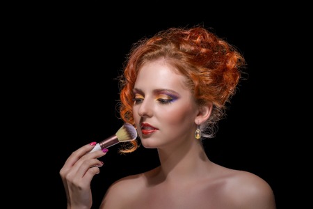 Beauty Portrait. Curly Hair on black background with make up brushの写真素材