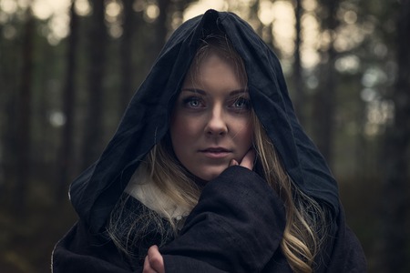 Young woman in Halloween witch costume in the autumn forestの写真素材