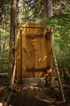 Wooden door on a walk way through the forestの写真素材