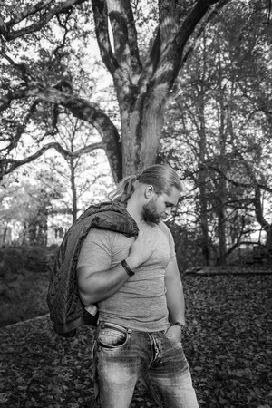 Longhair man posing in an autumn parkの写真素材