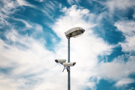 Security CCTV camera is installed in two directions at post on sky background