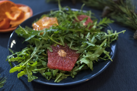 Rocket salad with oranges and grapefruit on a blue plateの写真素材