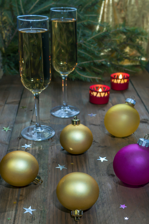 Wine glasses with champagne on a background of Christmas candles and balls and a Christmas tree. New Year's still-life background. 2018の写真素材