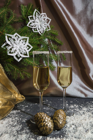 Two glasses with sparkling champagne for Christmas. Against the backdrop of New Year's fir-trees.の写真素材
