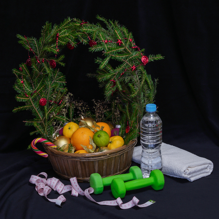 A large basket of fruit and Christmas balls. Crowned wreath of spruce branches. It is on the table. New Year of 2018.の写真素材