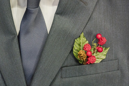 Business men's suit. In the pocket is a holly. Symbol of the coming new year. Christmas 2018