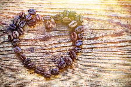 Coffee grains are lined in the shape of a heart on a wooden board. Valentine's Day.の写真素材