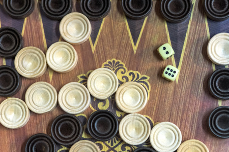 Wooden backgammon. Play a board game. The hand is throwing dice.の写真素材