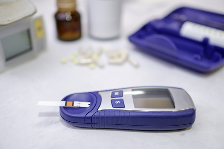 A medical test, checking a drop of blood on the sugar level. Pierce the finger with a lancet.の写真素材