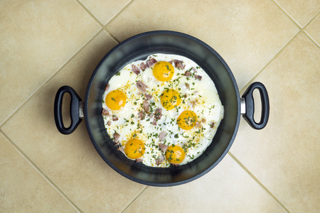 Fried eggs in a deep frying pan with bacon. Tasty food.の写真素材