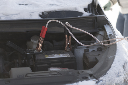The car did not start because of the cold temperature. The terminals are connected to the battery. Day, winter.の写真素材