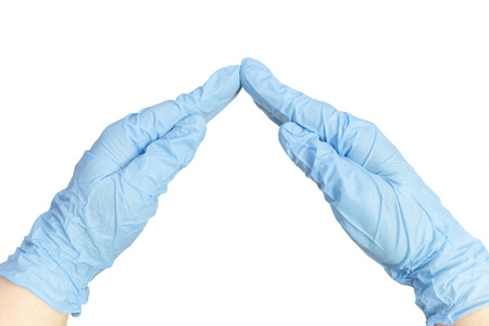 The doctor's hands in blue gloves in the form of a roof over the silhouette of the family. A symbol of care.の写真素材