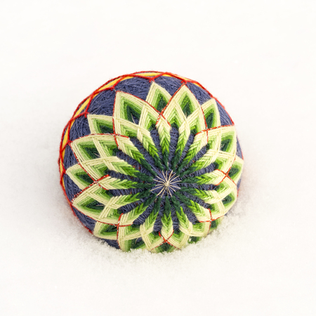 Bright decorative ball of the temari lie on the snow in the winterの写真素材