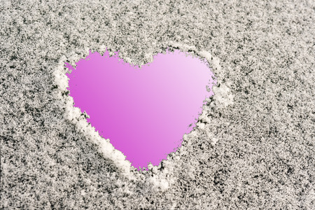 heart shape on a snowy surface, pink backgroundの写真素材