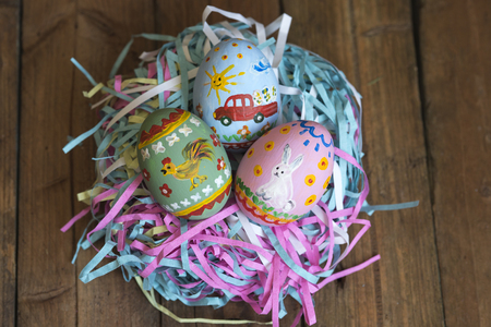 Painted eggs lie in a basket, wooden background, easterの写真素材