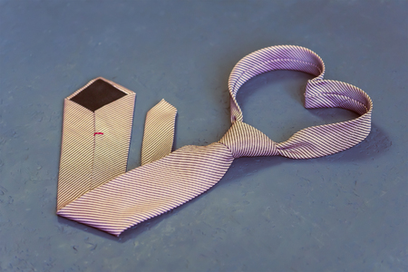 pink tie is tied in the shape of a heart on a gray background. The concept of love. Valentine's Dayの写真素材