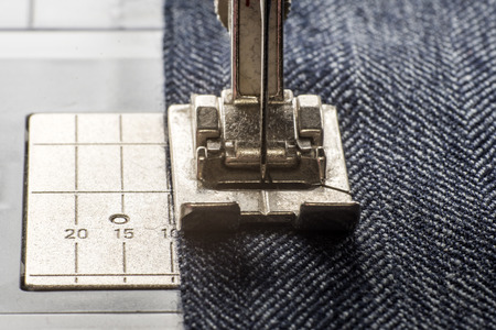 sewing machine sews denim fabric