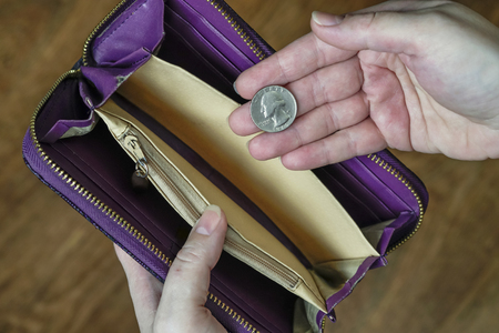 empty wallet and a hand with a quarter dollar
