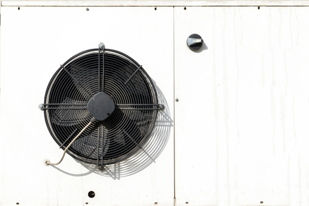 white metal housing air conditioning, black fan bladesの写真素材