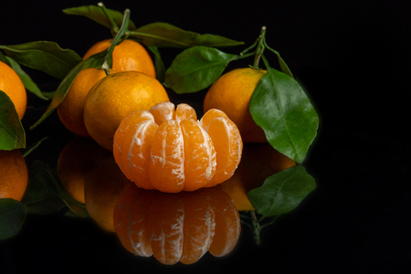 orange tangerines with leaves on a black background, new year and christmasの写真素材