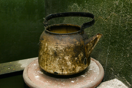 old metal teapot on background green wallの写真素材