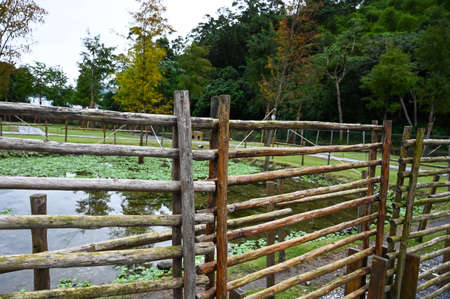 Wooden fence along the lake in the park.の写真素材