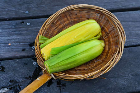 Golden corn placed on a bamboo tray.