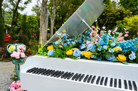 Artificial flower decoration on white piano.の写真素材