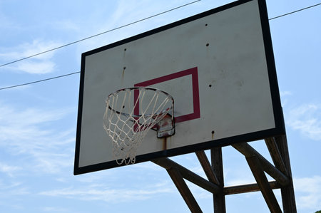 Basketball hoop closeup with blue sky and white clouds backgroundの写真素材